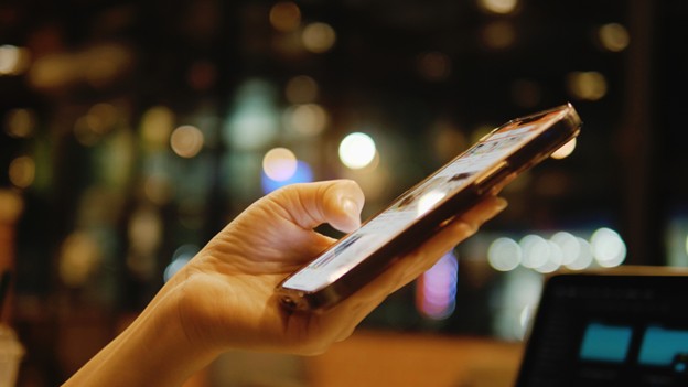 person holding a cell phone looking at a logistics marketing social media campaign